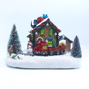 Détail d'un village de Noël en résine avec train miniature, bonhomme de neige et sapins