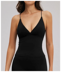 Détail de la brassière de sport noire avec fines bretelles et décolleté en V élégant