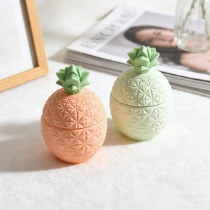Detail showing pink and mint green pineapple storage jars with textured leaf lids