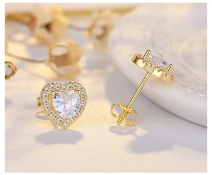 Macro shot of gold heart stud earrings with cubic zirconia and butterfly backings