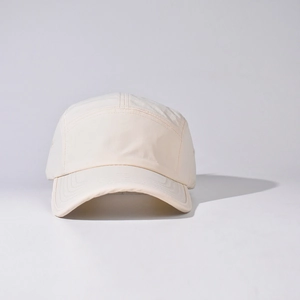 Detail view of a beige 5-panel camper hat with a minimalist short brim design