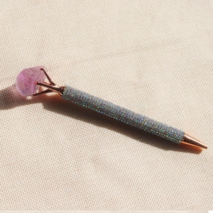 Detail of rose gold pen tip and barrel encrusted with silver rhinestones and purple crystal