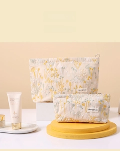 Close-up of floral embroidery on beige linen cosmetic bag set with zipper closure