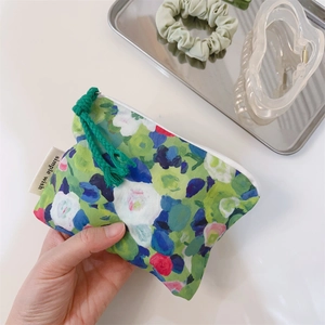 Detailed close-up of floral oil painting style mini pouch with woven cotton zipper puller
