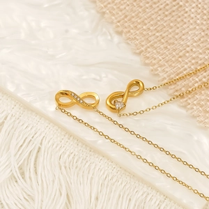 Elegant gold infinity symbol necklace with zircon accents on a woven decorative background