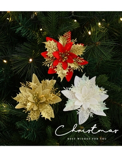 Sparkling poinsettia Christmas flowers in gold and red on a lit tree background