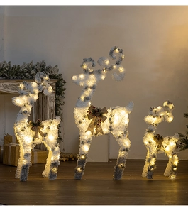 Detail of three light-up Christmas reindeer with warm LED lights and plush snow texture