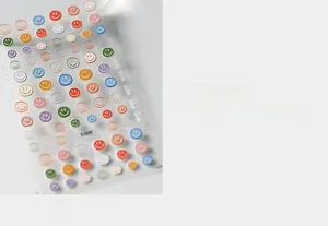 Close-up of S-029F multi-color smiley face nail art stickers with gold embossed details