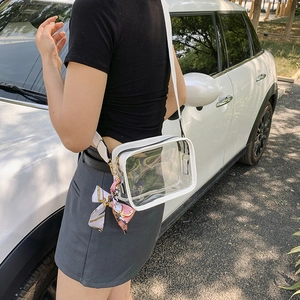 Detailed side view of clear PVC crossbody bag with white trim and a colorful silk scarf