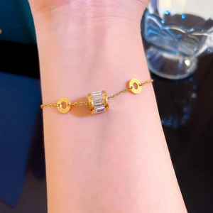 Bracelet en acier titane doré avec cylindre serti de cristaux et anneaux gravés