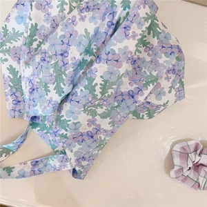 Detailed close-up of floral print cotton tote bag with a purple checkered hair scrunchie