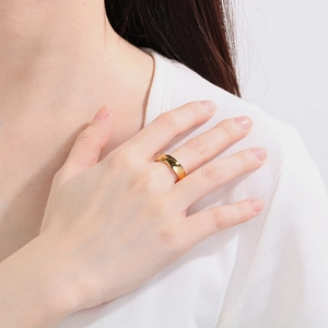 Close-up of minimalist 6mm 18K gold plated stainless steel ring worn on finger