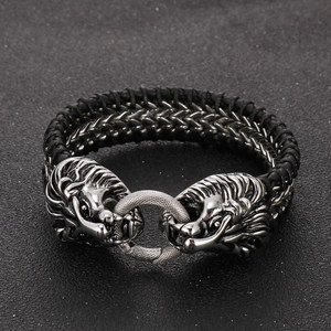 Detailed view of punk lion head charms on a black braided leather bracelet for men