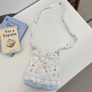 Detail of cartoon bear print crossbody bag with blue plaid trim and lace heart