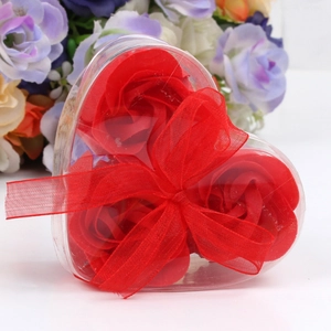 Detailed view of 3 red soap rose flowers in a heart-shaped transparent gift box