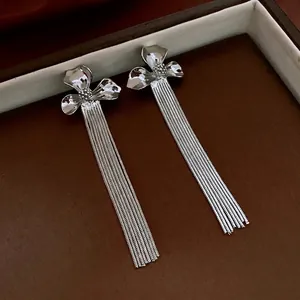 Elegant gold-plated flower stud earrings with long silver tassel chains in a gift box