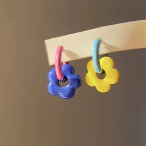 Close-up of vibrant floral earrings with pink blue and yellow contrast color design