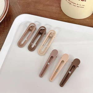 Set of six matte milk coffee hair clips in geometric shapes displayed on a white tray