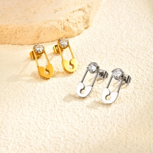 Stylish gold and silver safety pin earrings with cubic zirconia on stone base
