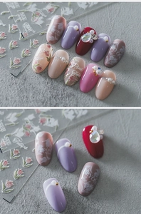 Makro-Detail von 5D-geprägten Tulpen-Nagelstickern mit Perlenakzenten auf glänzenden Nägeln