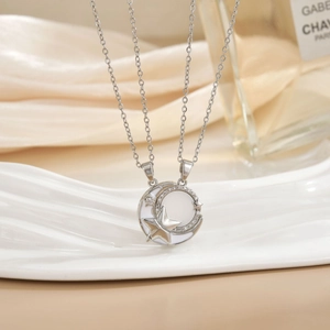 Detail of silver sun and moon pendant with pavé cubic zirconia and white enamel