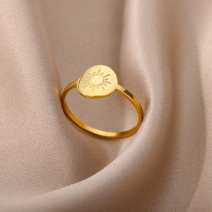 Macro detail of a minimalist 18K gold stainless steel ring with a sun pattern on silk