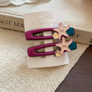 Close-up of star acrylic hair clips in purple and blue on jewelry card packaging