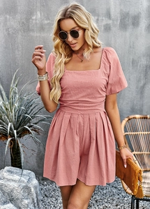 Detail of pink square neck romper showing fabric texture and elegant pleated waist design
