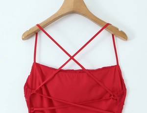 Détail de la robe rouge à bretelles avec laçage croisé sur un tissu en mousseline doux