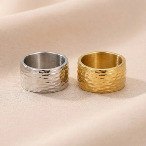 Macro detail of gold and silver stainless steel rings with irregular hammered texture