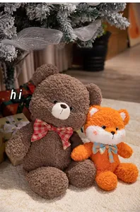 Close-up of plush teddy bear and fox toys with plaid bows in a festive Christmas setting