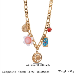 Detail view of gold Cuban chain necklace showing flower, ladybug and moon pendants with specs