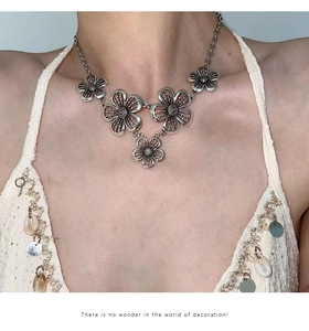Detail of bohemian silver hollow flower pendant necklace worn on neck with metal shine