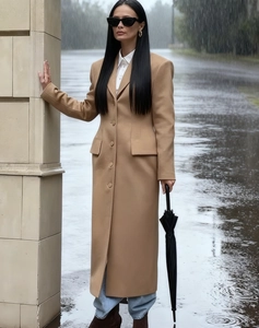 Detail of camel wool coat showing lapel collar and waist-slimming fit in street style