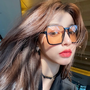 Retro oversized square sunglasses with black frame and orange gradient lenses on model