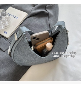 Spacious grey crescent bag interior showing phone and wallet with metal buckle detail