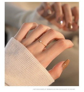 Close-up of minimalist gold S925 silver ring with small white zircon on a hand