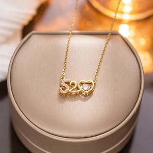 Elegant gold 520 heart pendant necklace with crystal on a beige jewelry box
