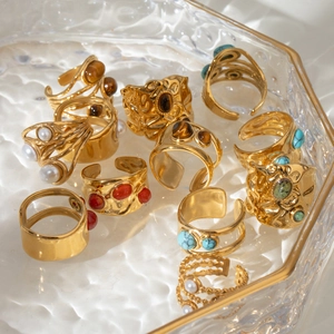 Bohemian gold stainless steel rings set featuring turquoise and pearls in a glass tray