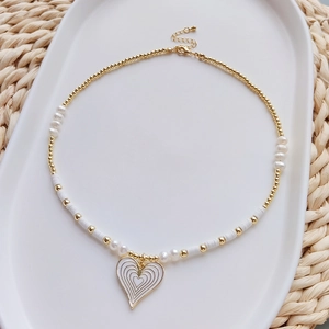 Bohemian daisy shell bead necklace with white enamel heart pendant and gold accents