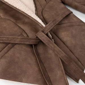 Detail of brown suede coat with white faux shearling lining and matching waist belt