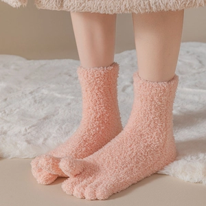 Detail of pink coral fleece five-finger socks with warm fuzzy texture and toe separation