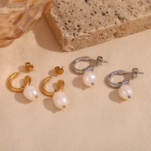 Detail of gold and silver hoop earrings with irregular freshwater pearl pendants