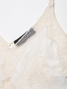 Detailansicht eines weißen Satin-Camisole-Tops mit feiner floraler Spitzenborte und Textur