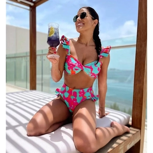 Detailed view of high-waisted bikini with ruffle straps and colorful tropical print