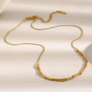 Detail of 18K gold-plated stainless steel chain with alternating beads and tube cylinders