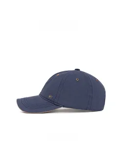 Detail view of navy blue baseball cap showing side metal plate and metallic ventilation eyelets