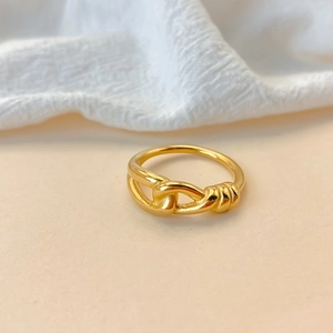 Primo piano di un elegante anello in acciaio inossidabile dorato su sfondo neutro