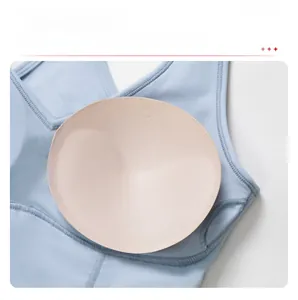 Detailed view of removable round chest pads on light blue breathable yoga sports bra
