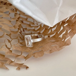 925 silver ring with rectangular zircon and textured stripe band on brown paper